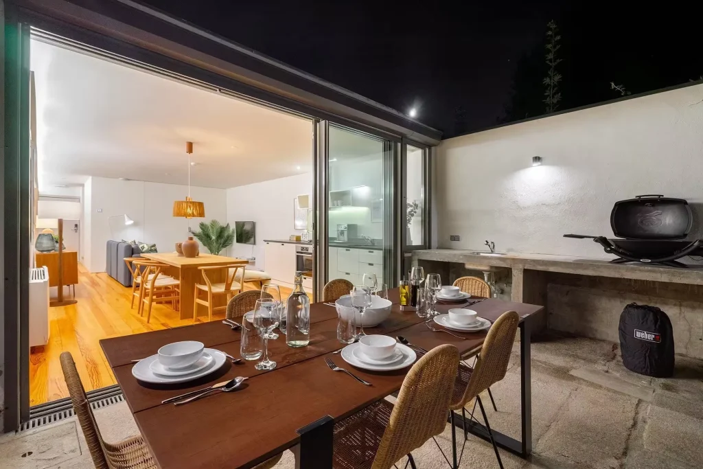 Outdoor kitchen and dining table at 14 Acres lit up in the evening