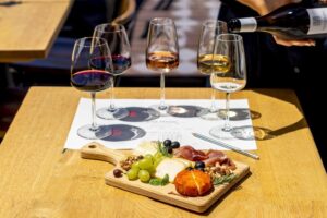 Wine tasting with a charcuterie board featuring cheeses, grapes, nuts, olives, and cured meats on a wooden table at 14 Acres.
