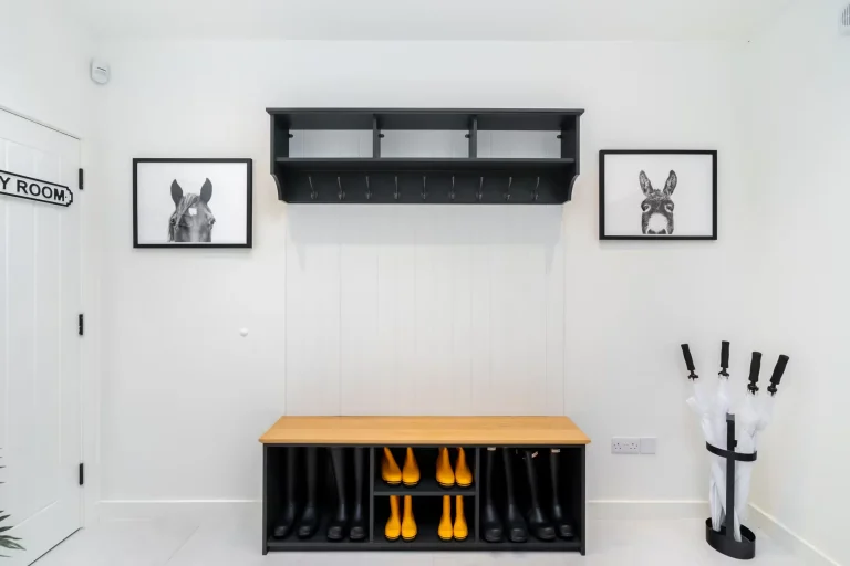 Stylish boot room interior at 14 Acres with black and yellow Hunter wellington boots, horse and donkey art, and umbrella stan