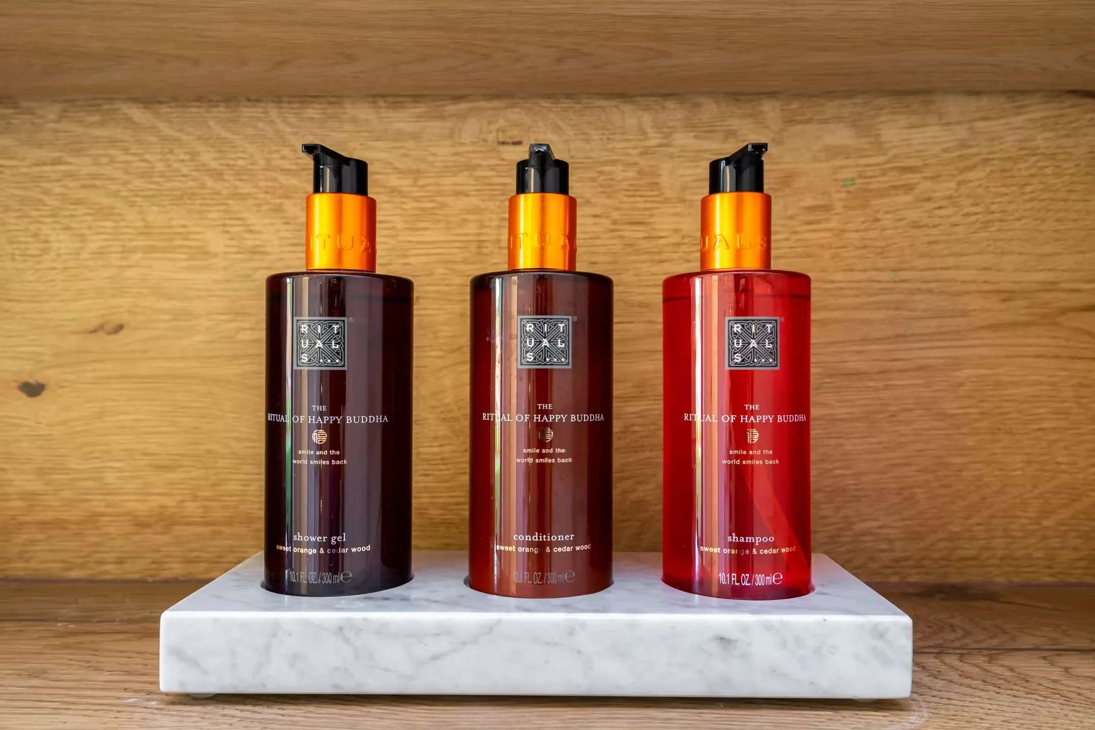 Three Rituals 'The Ritual of Happy Buddha' toiletries on a marble tray against a wooden background at 14 Acres.