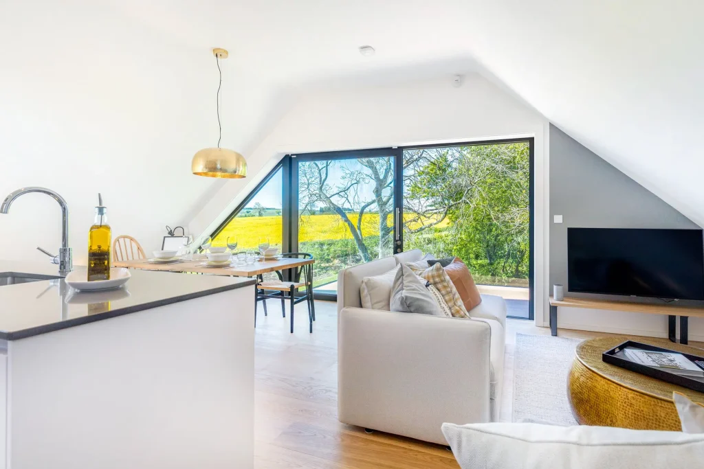 Open-plan living space in The Loft at 14 Acres with a glass wall onto the balcony