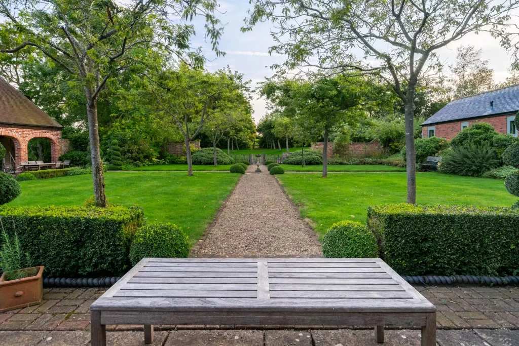 A gravel path through the formal garden at 14 Acres, framed by clipped hedges and trees