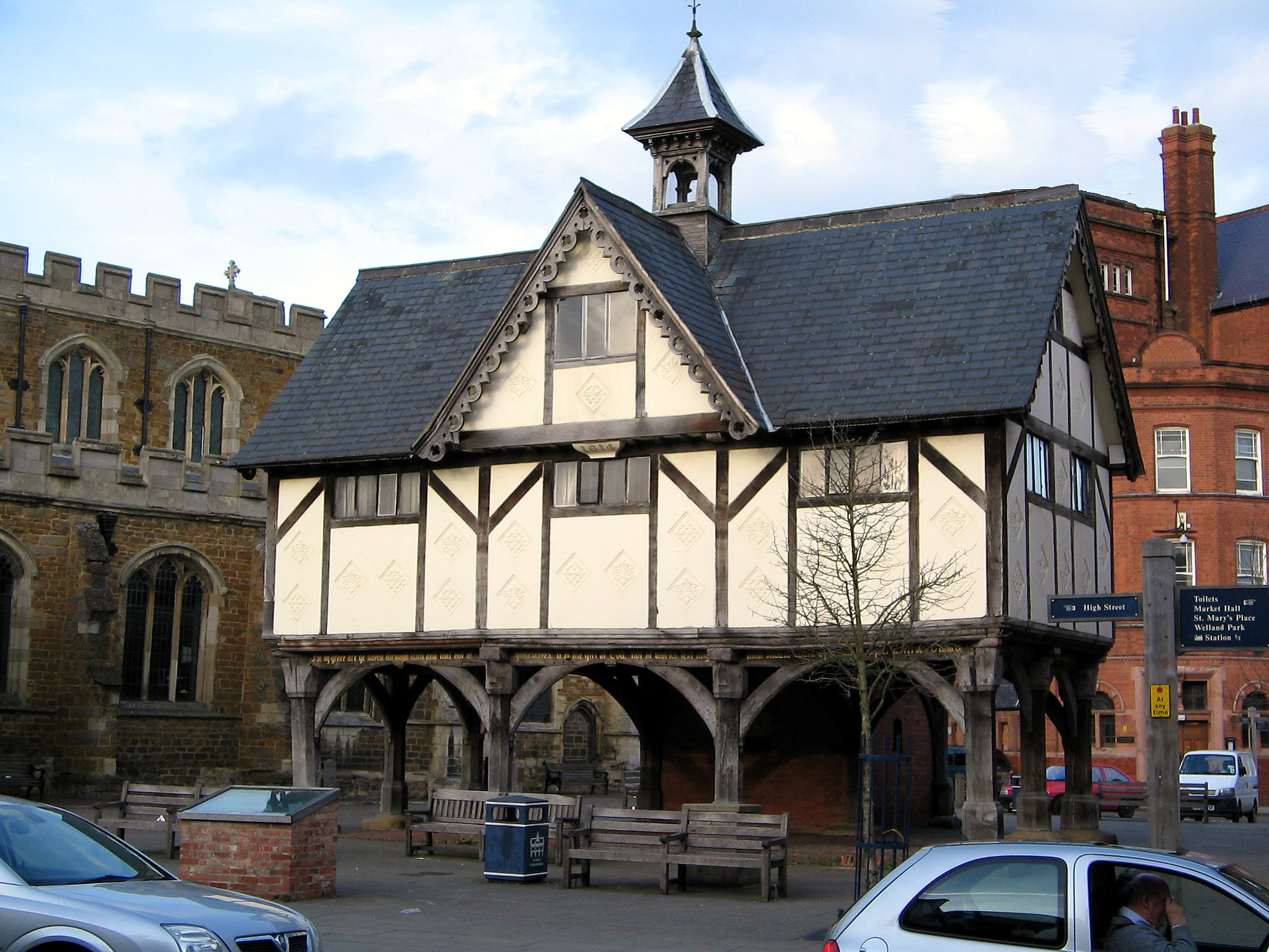 The Old Grammar School in Market Harborough, a timber-framed building of 1614 raised on wooden pillars beside St Dionysius Church