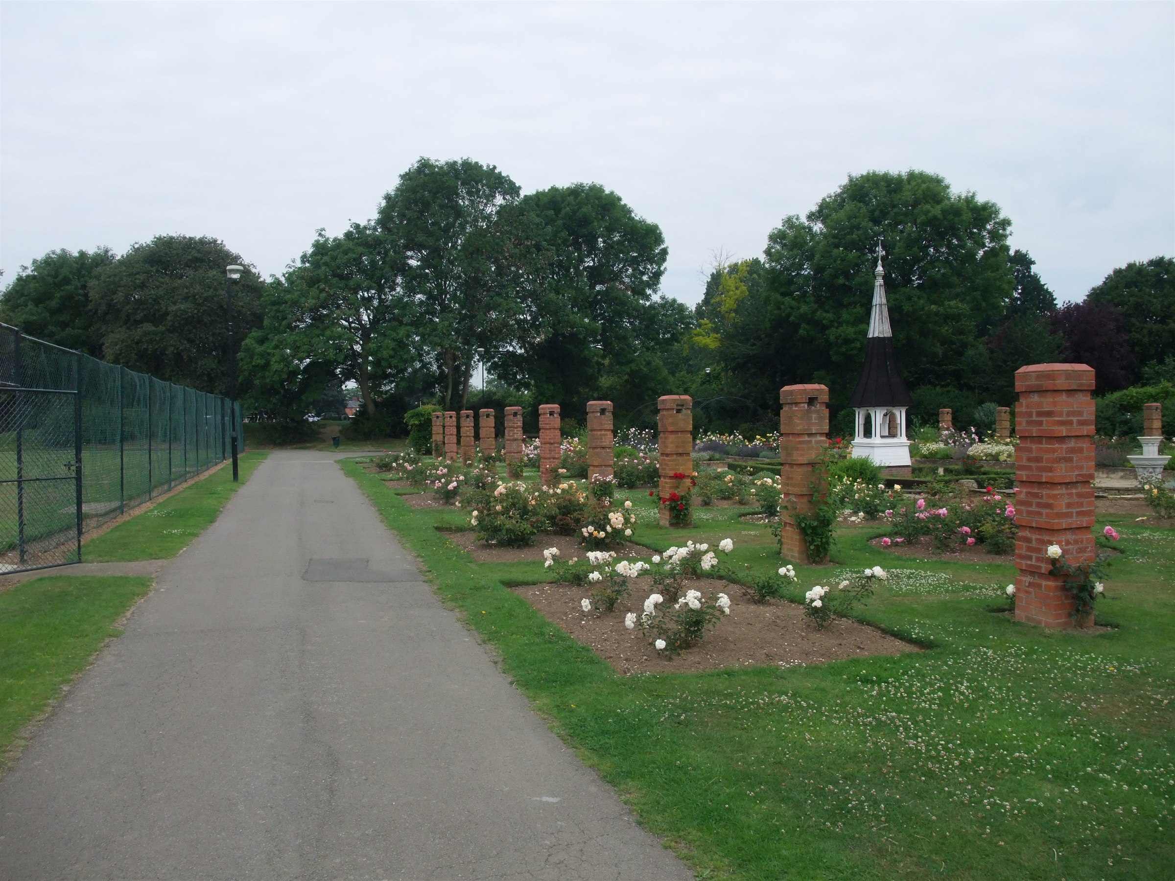 The rose garden at Welland Park in Market Harborough, with brick pillars, formal beds and a white cupola