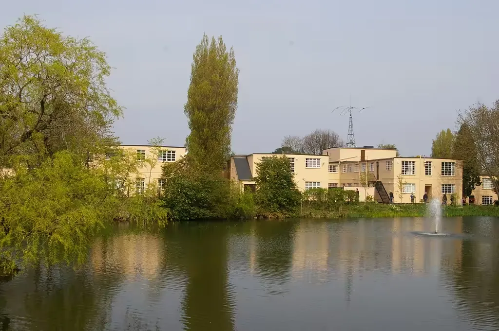 Cream-painted buildings beside a lake with a fountain