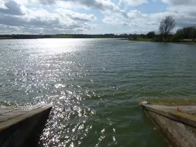 Sunlight on open water at a reservoir, seen from a concrete slipway