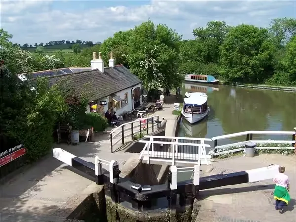 Canal lock gates, narrowboats and a canalside cottage at Foxton Locks