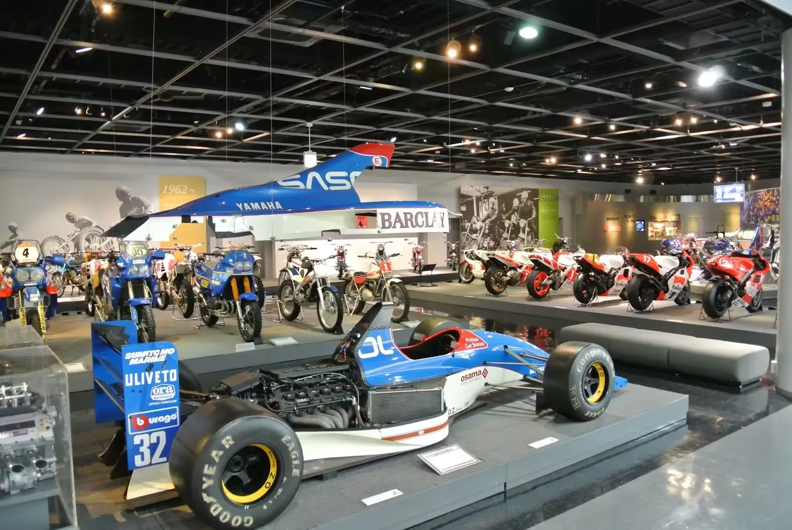 Formula One car and racing motorcycles on display in a motorsport museum