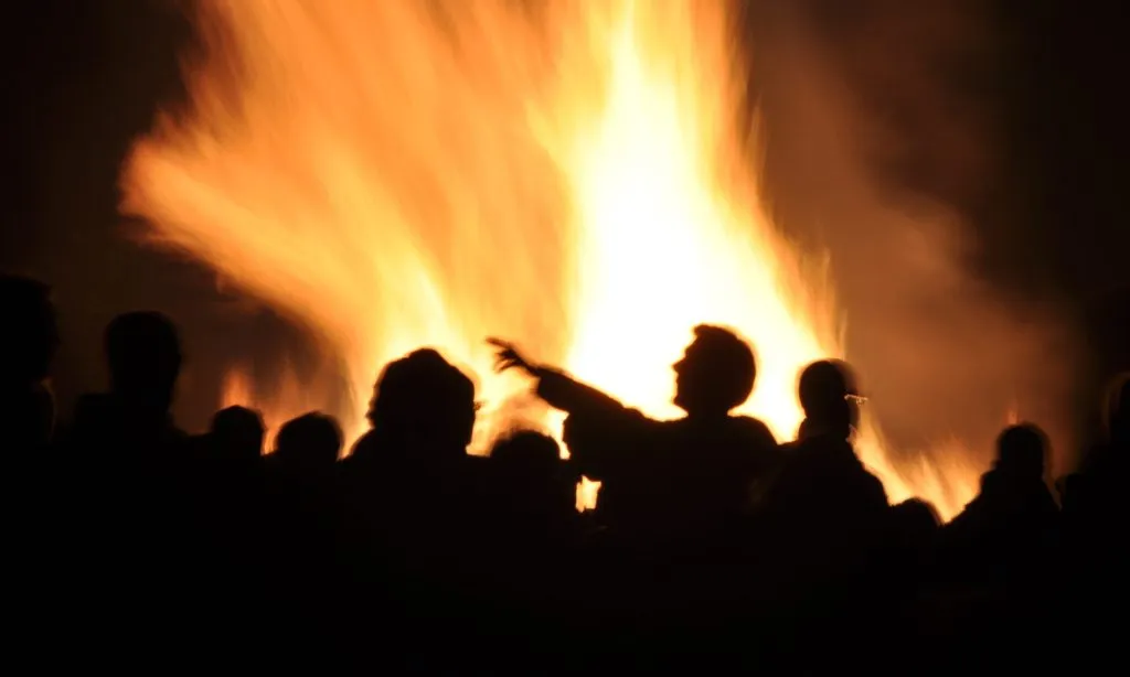 A crowd silhouetted against a large bonfire on Bonfire Night in England