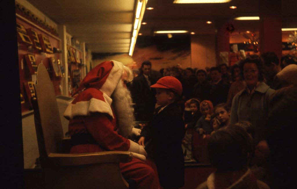 A young boy meeting Father Christmas in a traditional department store grotto