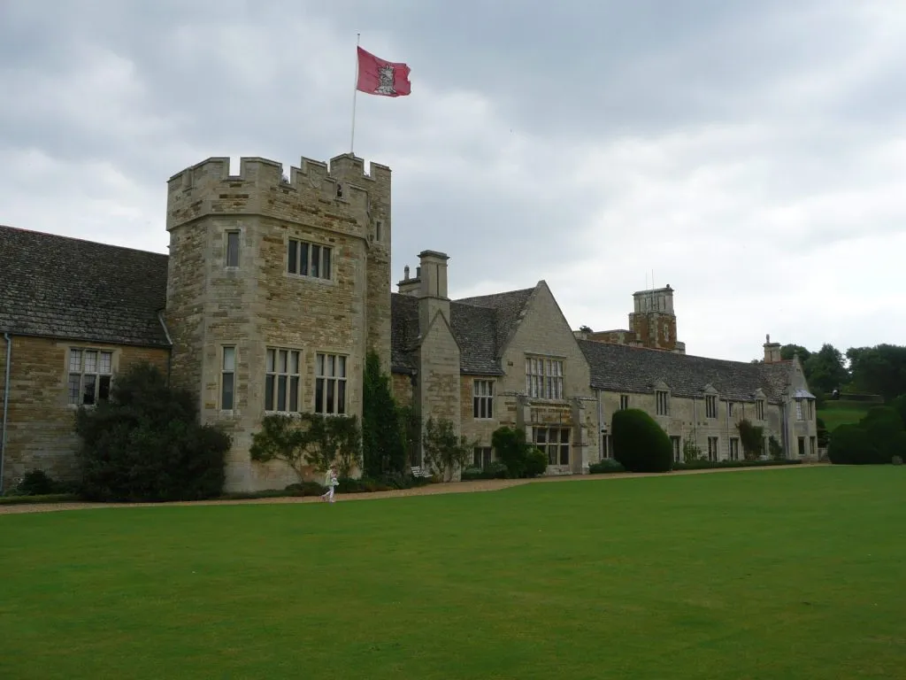 Rockingham Castle's stone tower and lawn under an autumn sky